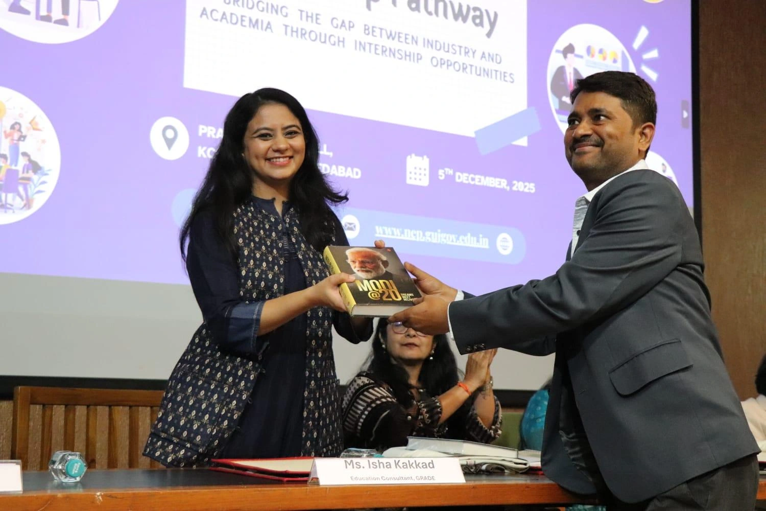 Isha Kakkad Lakhani receiving a book at the Knowledge Consortium of Gujarat